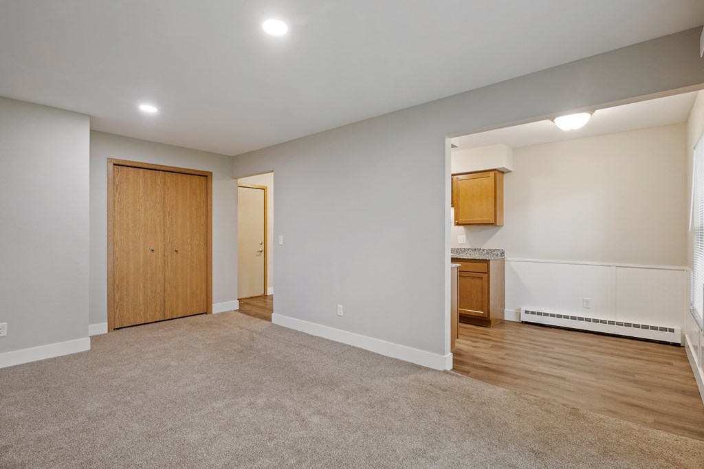 A room with a carpeted floor and a wooden door.