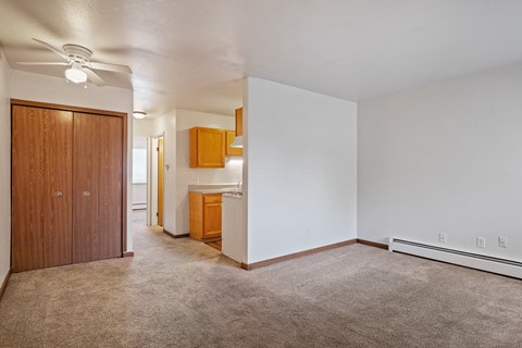 A room with a carpeted floor and a ceiling fan.