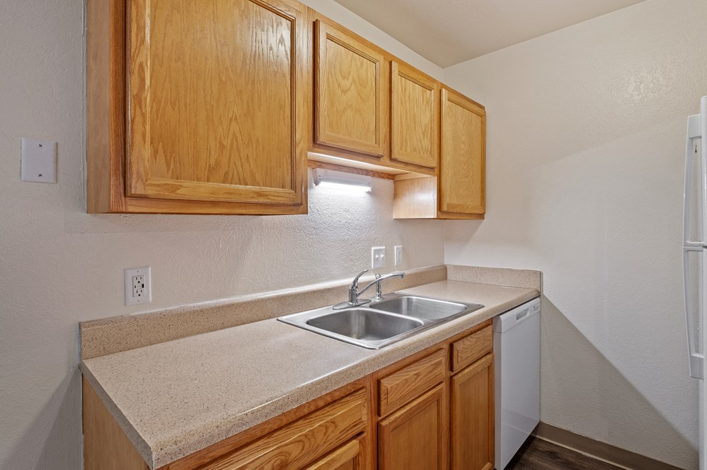 A kitchen with wooden cabinets and a white refrigerator.