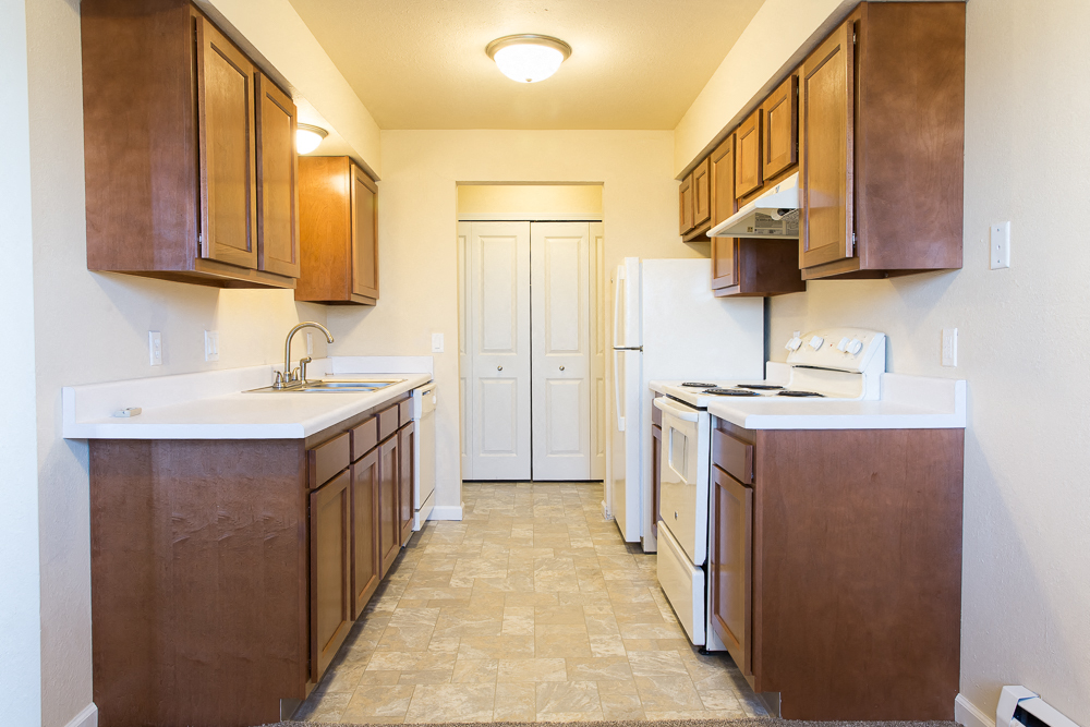 a kitchen with wooden cabinets and white appliances and a door