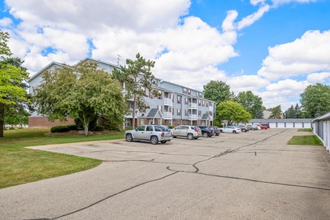 A parking lot with cars and a building in the background.
