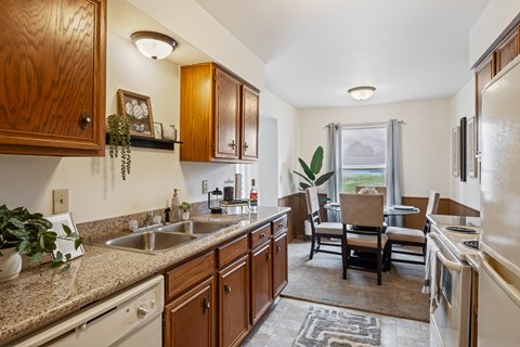 A kitchen with wooden cabinets and a granite countertop.