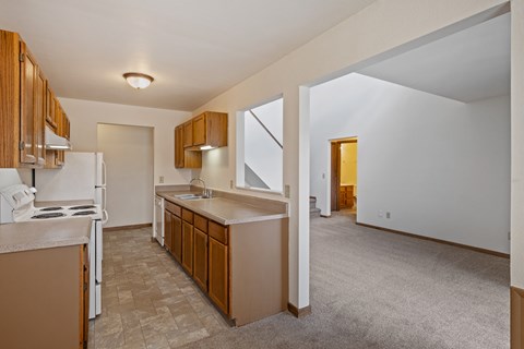 A kitchen with brown cabinets and a white refrigerator.
