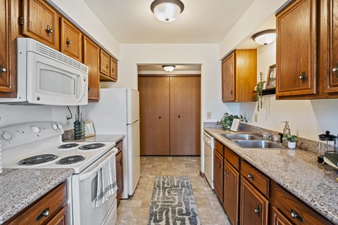 A kitchen with a white stove and wooden cabinets.