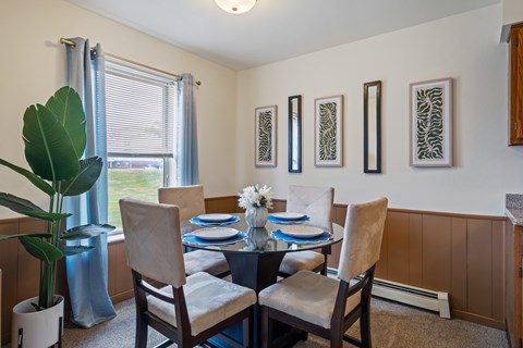 A dining room with a table set for four.