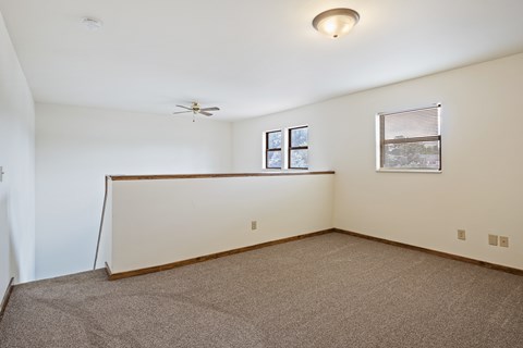 Empty room with a fan and a window.