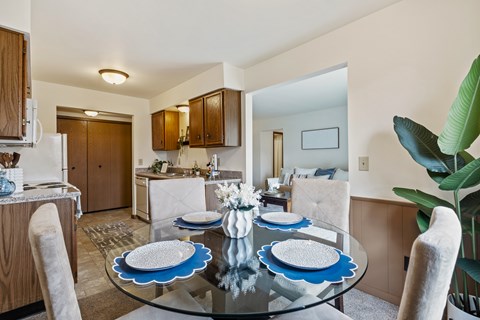 A dining room with a glass table and blue plates.
