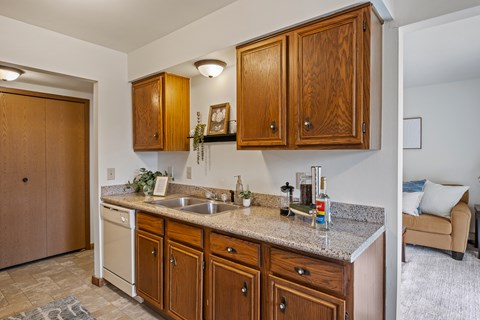 A kitchen with wooden cabinets and a granite countertop.