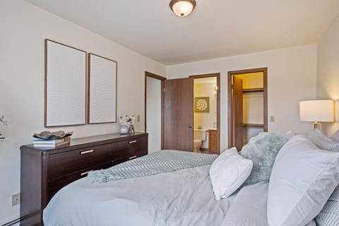 A bedroom with a bed, nightstand, and a lamp.