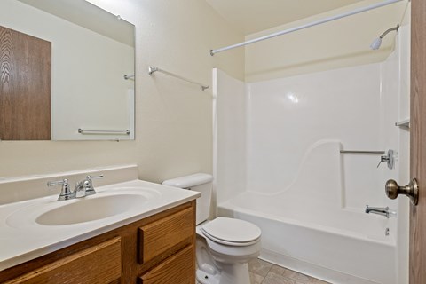 A white bathroom with a toilet, sink, and bathtub.