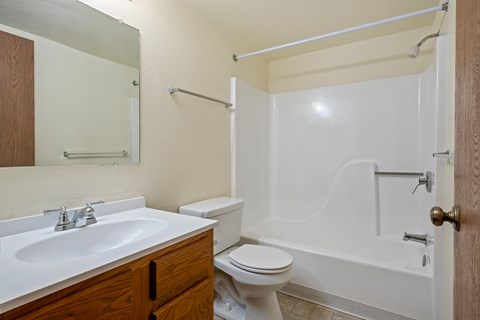 A bathroom with a white toilet, sink, and bathtub.