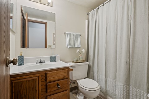 A white toilet sits next to a white sink in a bathroom.