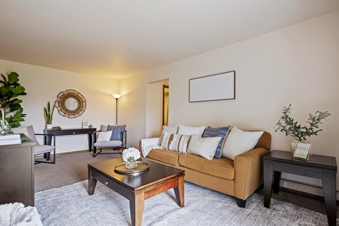 A living room with a brown couch and a coffee table.