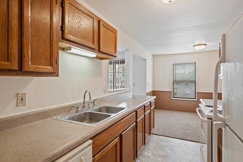 A kitchen with brown cabinets and a stainless steel sink.