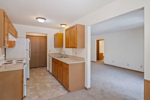 A kitchen with brown cabinets and a white refrigerator.