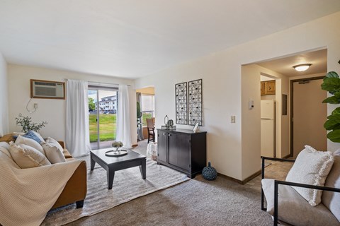 A living room with a sofa, a coffee table, and a television.