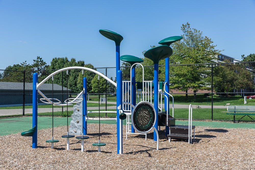 a playground with a swing set and slides at a park