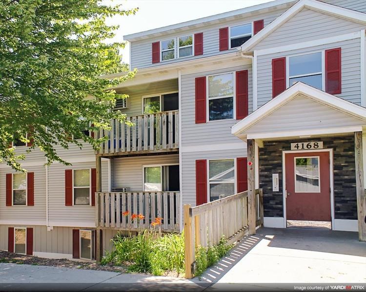 a red and white house with a porch and a tree