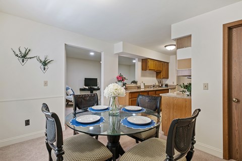 A dining room with a glass table and chairs.