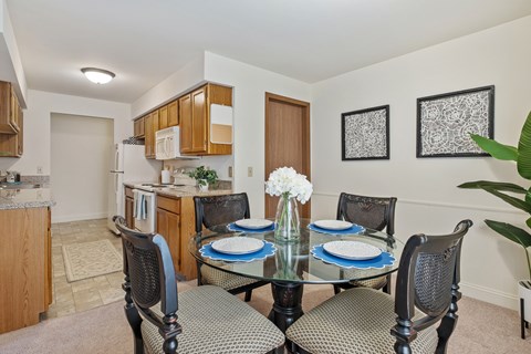 A dining room with a glass table and chairs.