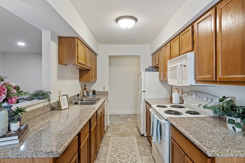A kitchen with wooden cabinets and granite countertops.