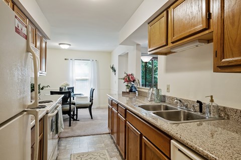 A kitchen with wooden cabinets and a granite countertop.