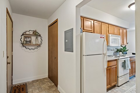 A kitchen with a refrigerator, microwave, and oven.