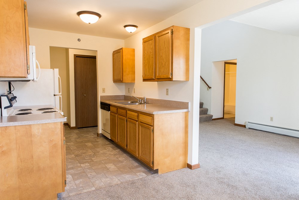 an empty kitchen with wooden cabinets and a counter top in a house