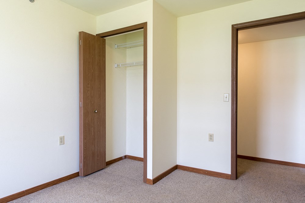 an empty room with a closet and a mirror