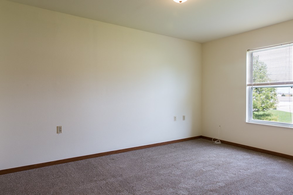 an empty room with carpet and a window