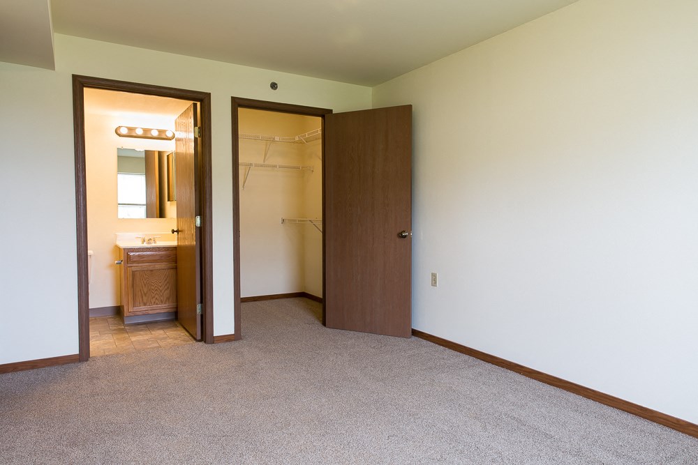 an empty bedroom with a closet and a bathroom