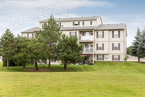 a large house on a hill with trees in front of it