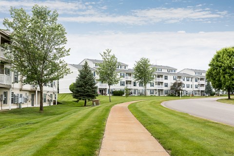 a sidewalk leading to a row of houses on the side of a road