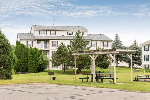a picnic area in a park in front of an apartment building