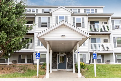 a white apartment building with blue signs in front of it