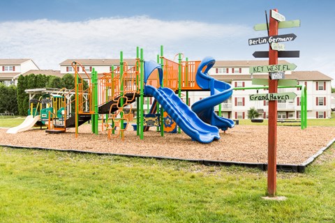 a playground with a blue slide at a school