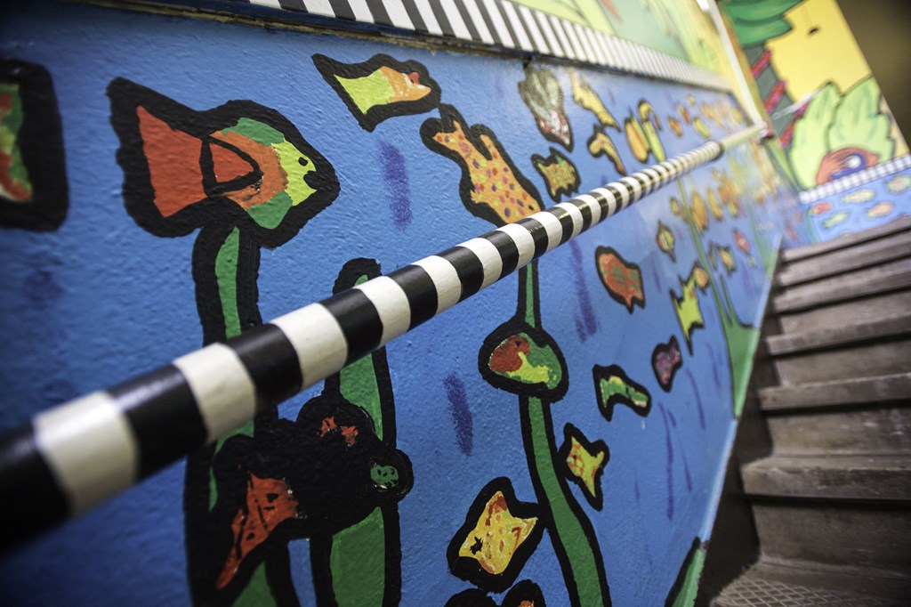 a mural of flowers on a wall next to a staircase
