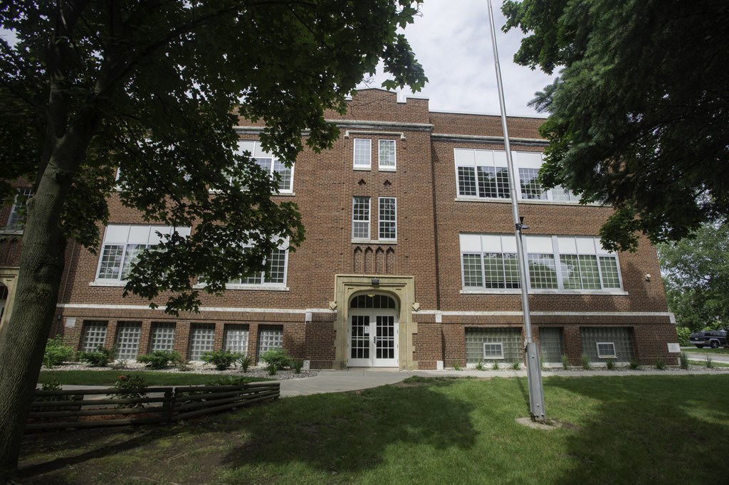 a large brick building with a flagpole in front