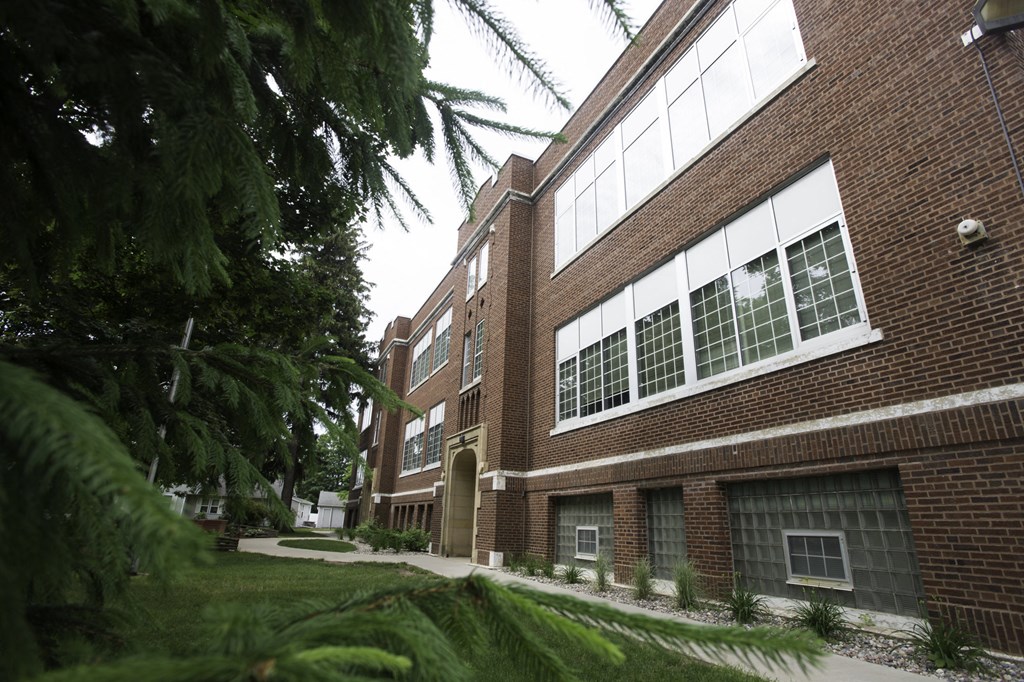 a large brick building with a sidewalk in front of it