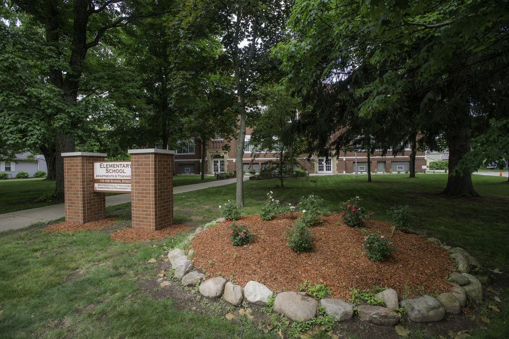 a circle of rocks and trees in front of a sign