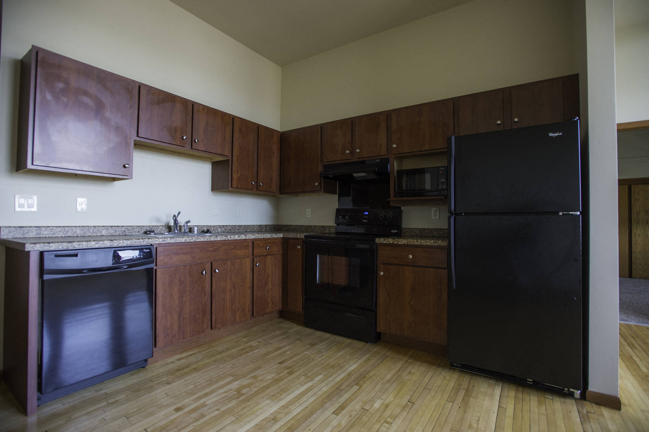 a kitchen with black appliances and wooden cabinets
