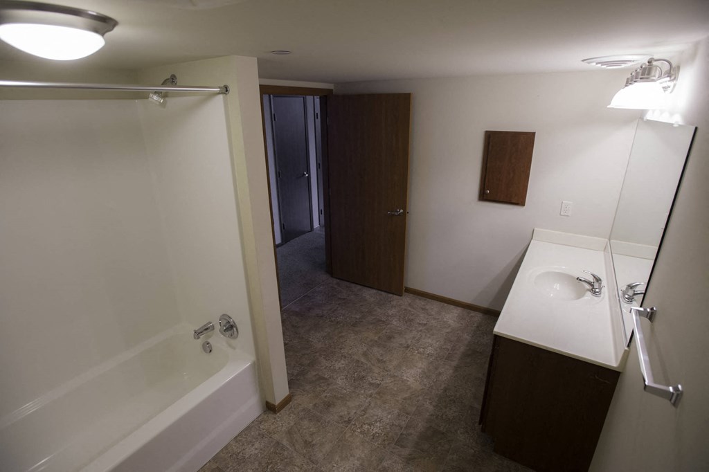 a bathroom with a shower and a sink and a mirror