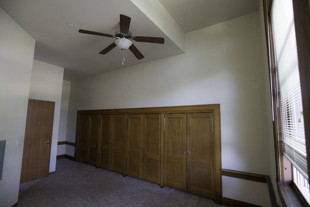 a bedroom with a ceiling fan and a closet