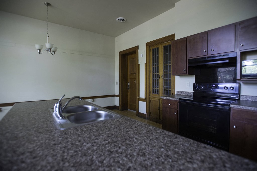 an empty kitchen with a sink and a counter