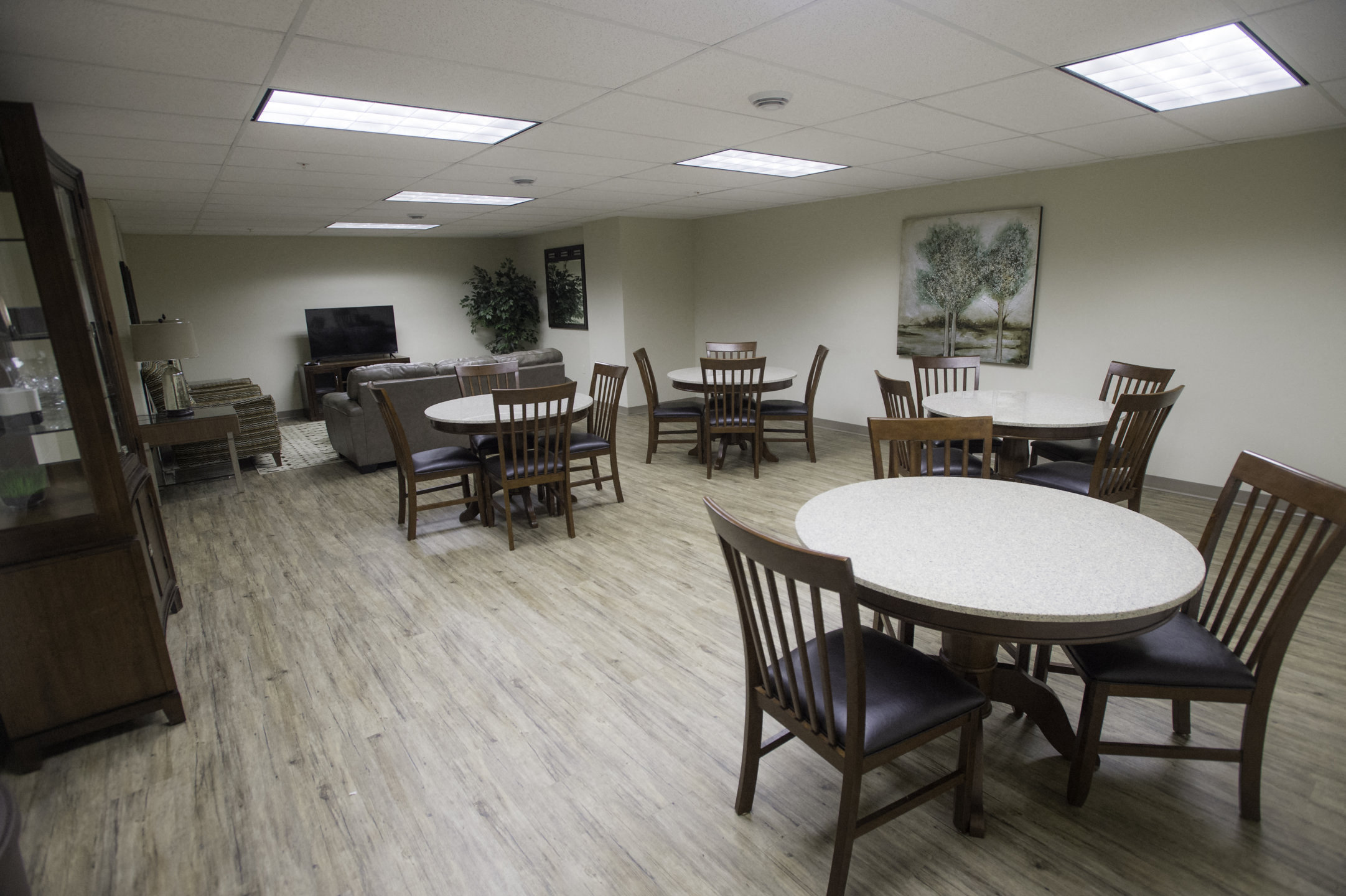 a dining room with tables and chairs and a living room with a couch