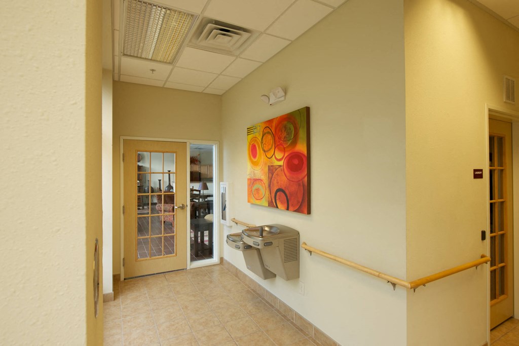 a hallway with a urinal and a painting on the wall