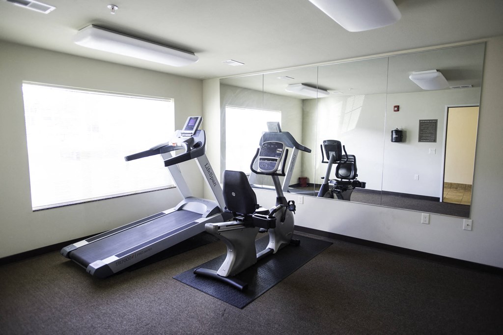 a gym with two machines and a large mirror