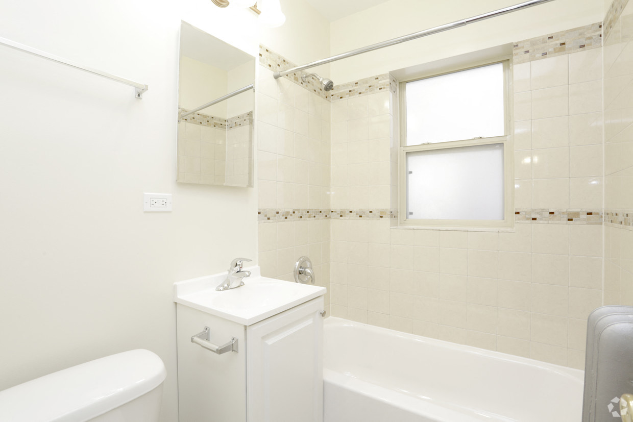 a white bathroom with a tub and a sink