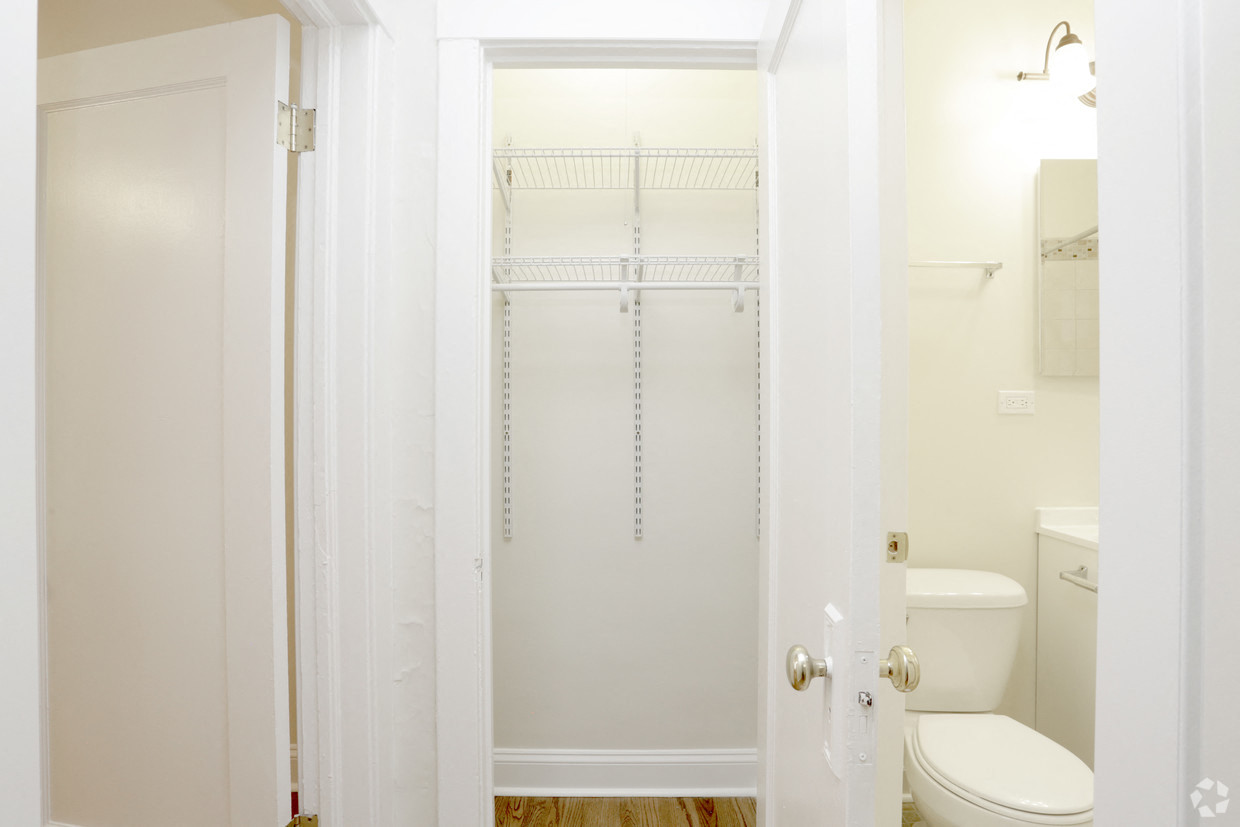 a bathroom with a shower and a toilet and a closet
