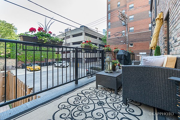 a small balcony with a table and chairs and a city street